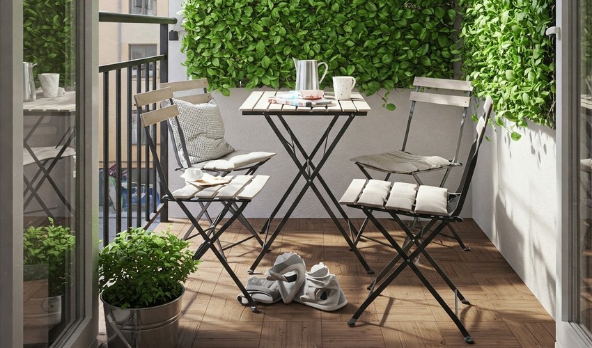 Small Dubai balcony with smart foldable furniture and green wall.